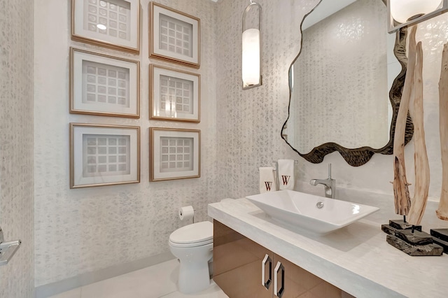 bathroom with toilet, vanity, and tile patterned floors