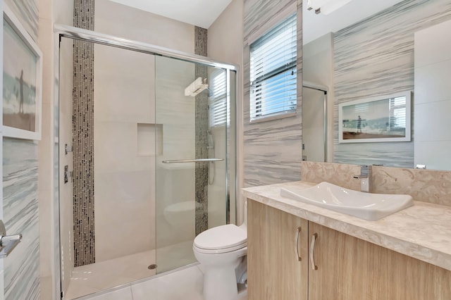 bathroom featuring tile walls, walk in shower, vanity, and toilet