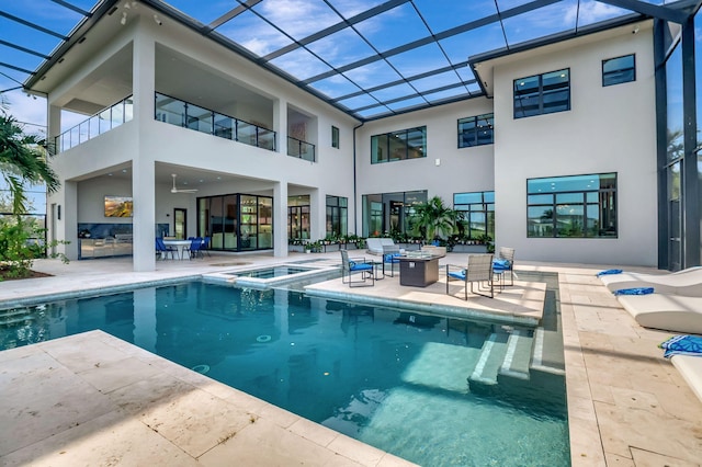 back of house featuring a lanai, a swimming pool with hot tub, and a patio area