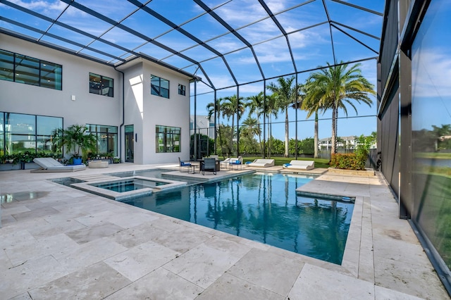 view of pool with a patio, glass enclosure, and an in ground hot tub