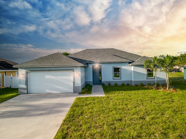 view of front of house with a garage and a yard