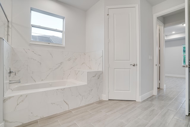 bathroom with a relaxing tiled tub