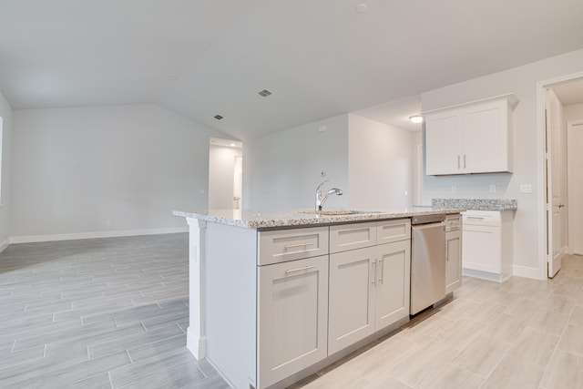 kitchen featuring a center island with sink, vaulted ceiling, dishwasher, sink, and white cabinetry