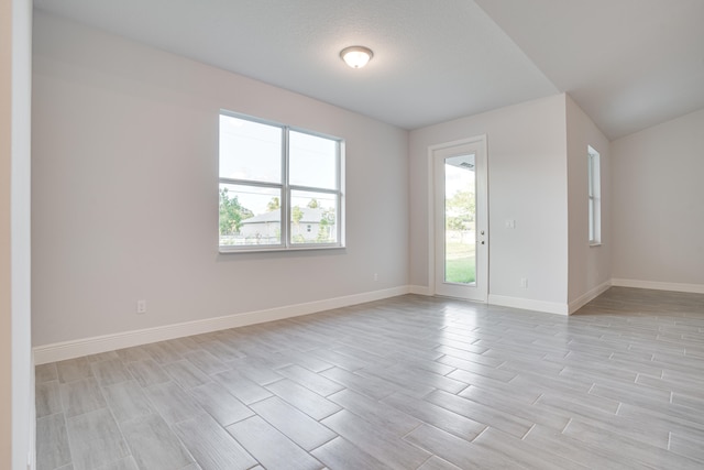 empty room with light hardwood / wood-style flooring and a textured ceiling