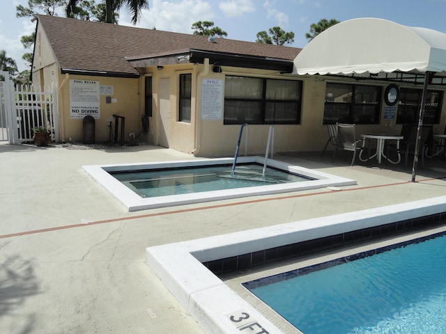 view of swimming pool featuring a hot tub