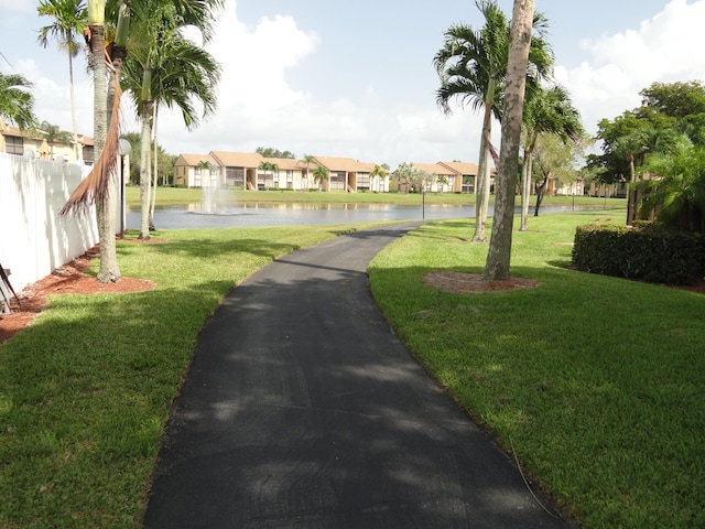 surrounding community featuring a water view and a yard