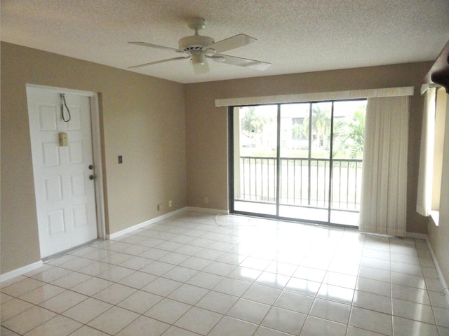 tiled empty room with ceiling fan and a textured ceiling