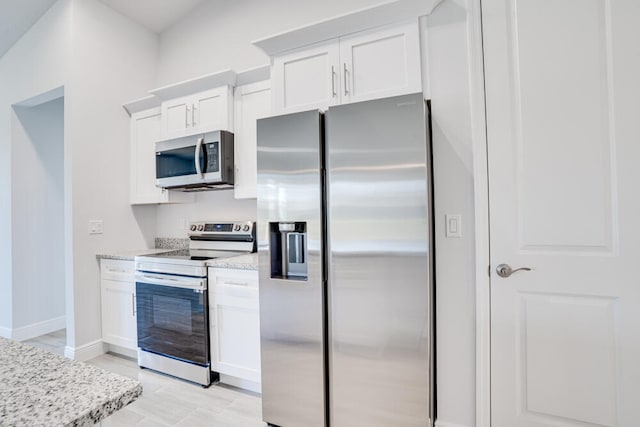 kitchen featuring light stone countertops, white cabinetry, and appliances with stainless steel finishes