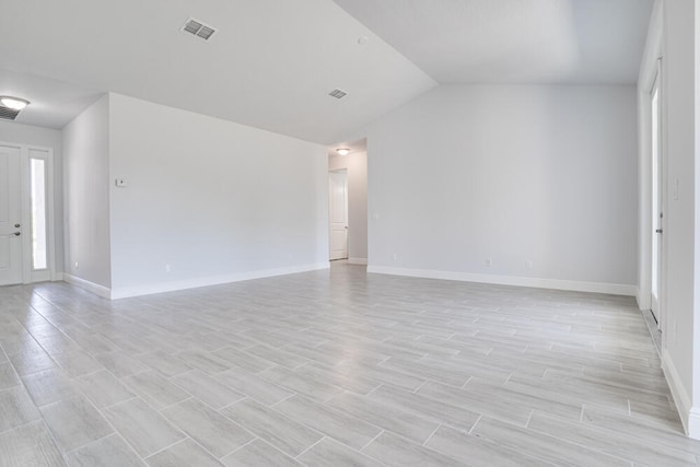 unfurnished room with light wood-type flooring and vaulted ceiling