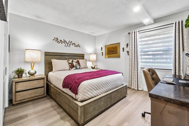 bedroom with a textured ceiling and light wood-type flooring