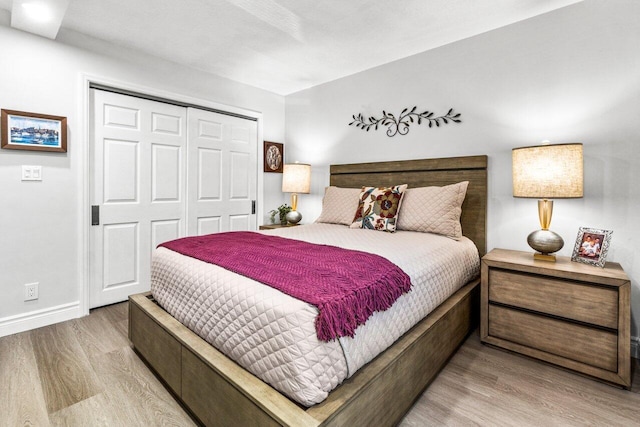 bedroom with light hardwood / wood-style flooring and a closet