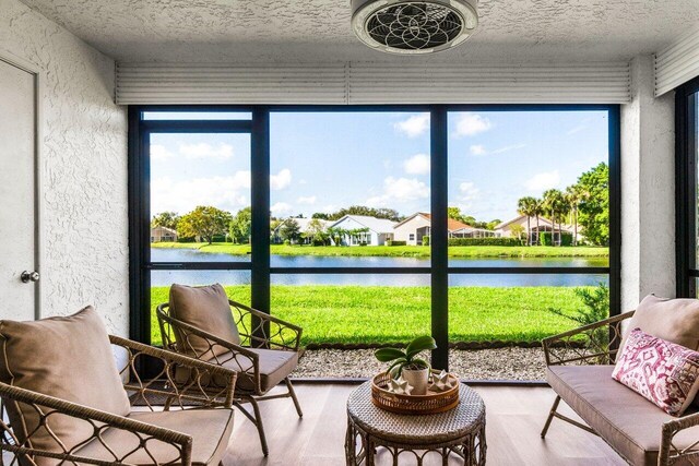 sunroom with plenty of natural light and a water view