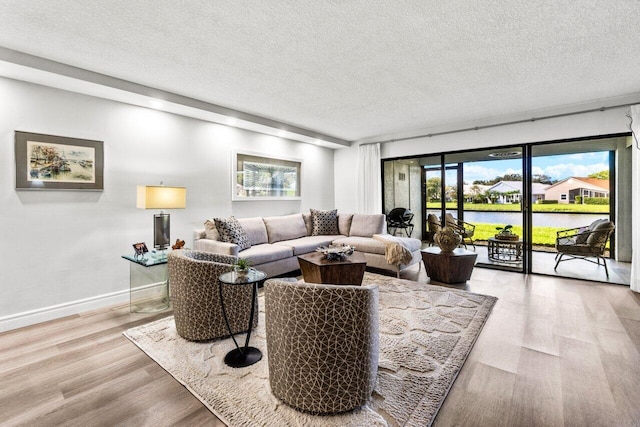 12871 Briarlake Dr Unit 102, Palm Beach Gardens, FL 33418 - living area with wood finished floors, a textured ceiling, a water view, and baseboards