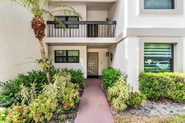 view of exterior entry featuring a balcony