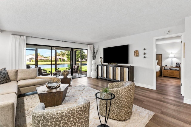 living room with dark wood-type flooring and a textured ceiling