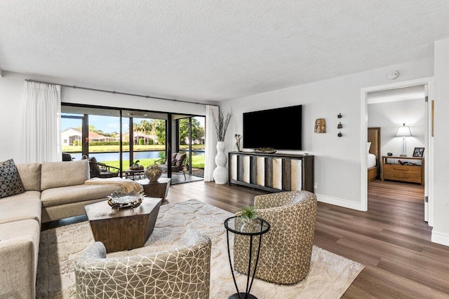 12871 Briarlake Dr Unit 102, Palm Beach Gardens, FL 33418 - living area featuring a textured ceiling, wood finished floors, and baseboards