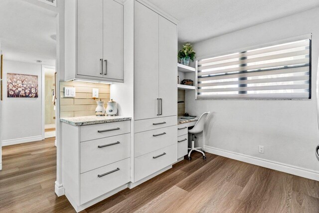 office area featuring built in desk and light hardwood / wood-style flooring