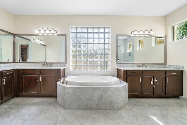 bathroom with vanity and a relaxing tiled tub