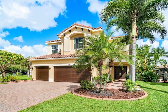 mediterranean / spanish home featuring a front lawn and a garage