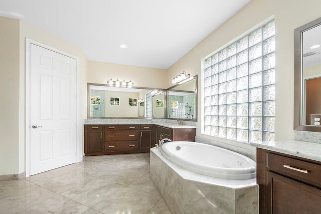 bathroom featuring vanity and a relaxing tiled tub