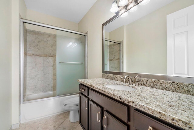 full bathroom with an inviting chandelier, tile patterned floors, bath / shower combo with glass door, toilet, and vanity