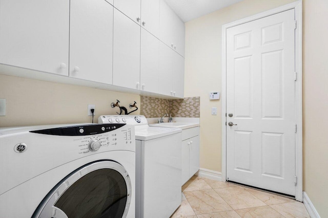 laundry room with washer and dryer, light tile patterned flooring, cabinets, and sink