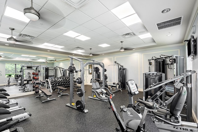 workout area featuring ceiling fan, a drop ceiling, and ornamental molding