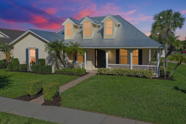 view of front of house with a porch and a lawn