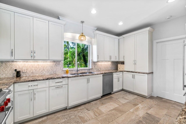 kitchen with appliances with stainless steel finishes, sink, pendant lighting, stone counters, and white cabinetry