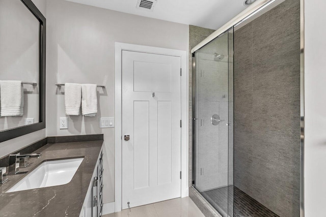 bathroom with vanity and a shower with door