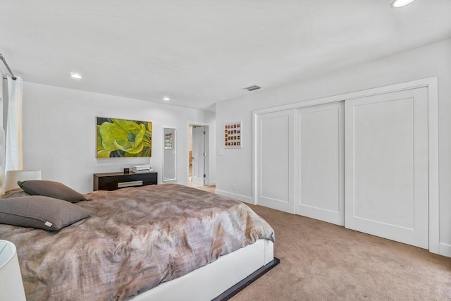 bedroom featuring light carpet and a closet