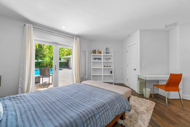 bedroom featuring access to exterior, built in desk, and dark hardwood / wood-style floors