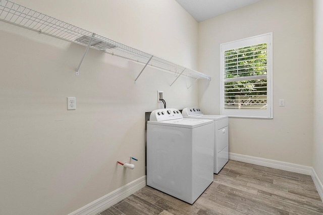 washroom featuring washer and clothes dryer and light wood-type flooring