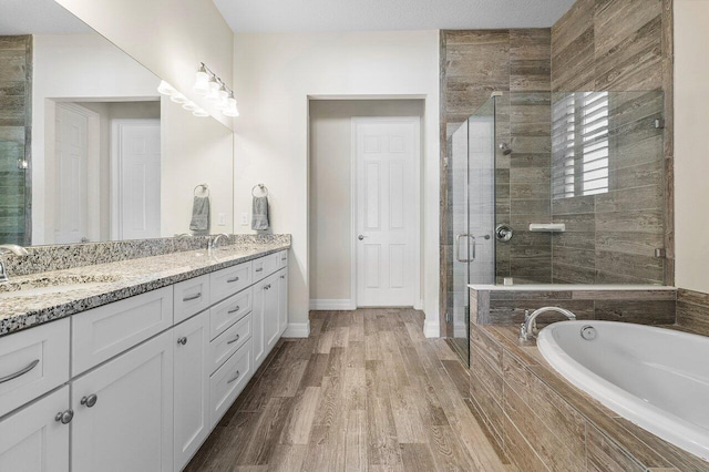 bathroom featuring plus walk in shower, wood-type flooring, and vanity