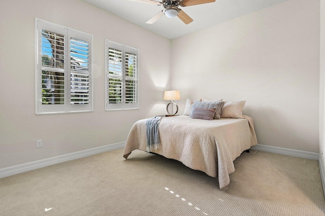 bedroom with ceiling fan and light carpet