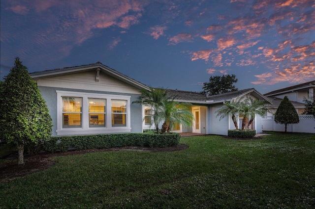 ranch-style home with a yard