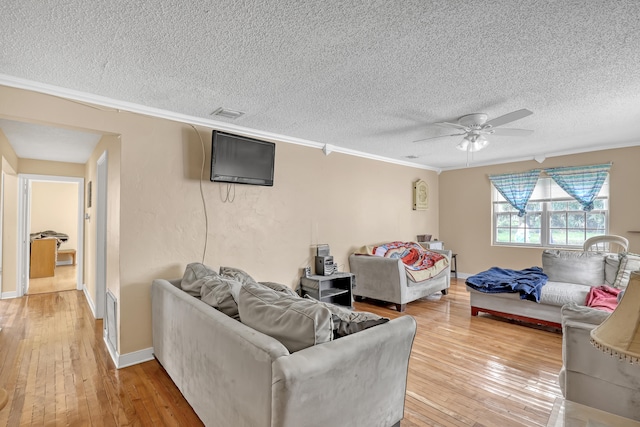 dining space featuring ceiling fan with notable chandelier, sink, vaulted ceiling with skylight, light wood-type flooring, and a textured ceiling