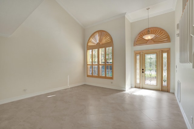 tiled foyer entrance featuring ornamental molding and a high ceiling