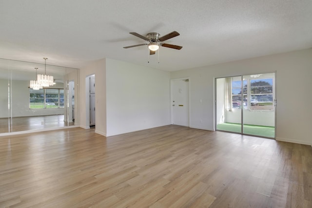 unfurnished living room with a textured ceiling, light hardwood / wood-style flooring, and ceiling fan with notable chandelier