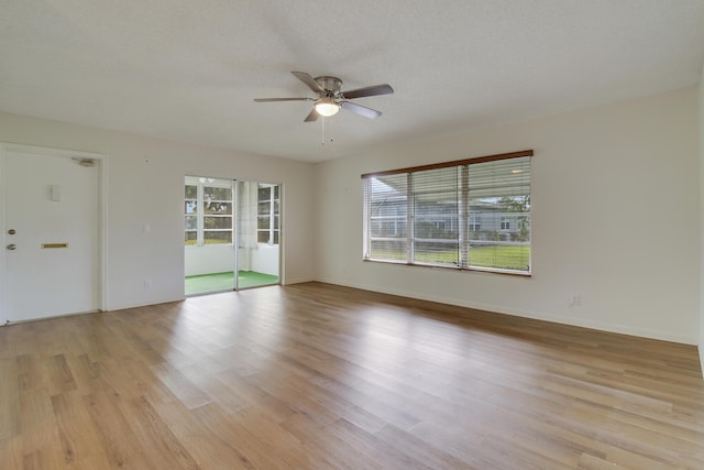 unfurnished room featuring ceiling fan, light hardwood / wood-style floors, and a textured ceiling