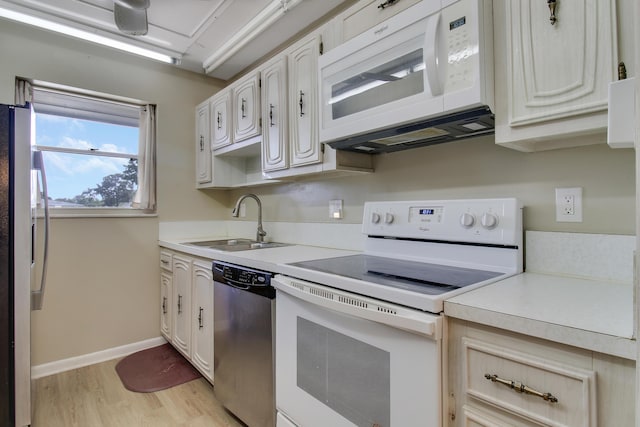 kitchen featuring white cabinetry, sink, light hardwood / wood-style floors, and white appliances