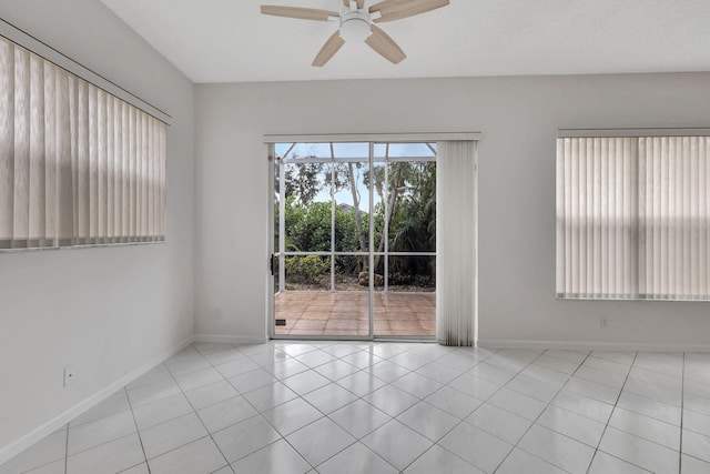 tiled empty room featuring ceiling fan