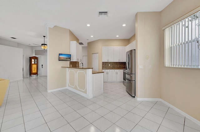 kitchen with stainless steel refrigerator, white cabinetry, sink, kitchen peninsula, and ceiling fan