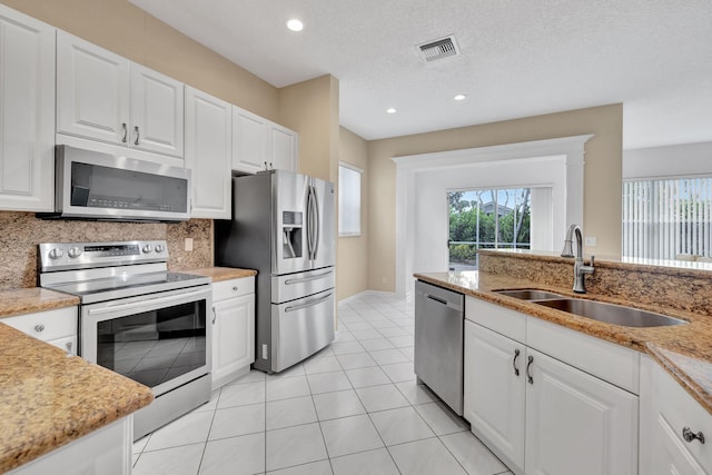 kitchen with white cabinets, a textured ceiling, sink, and appliances with stainless steel finishes