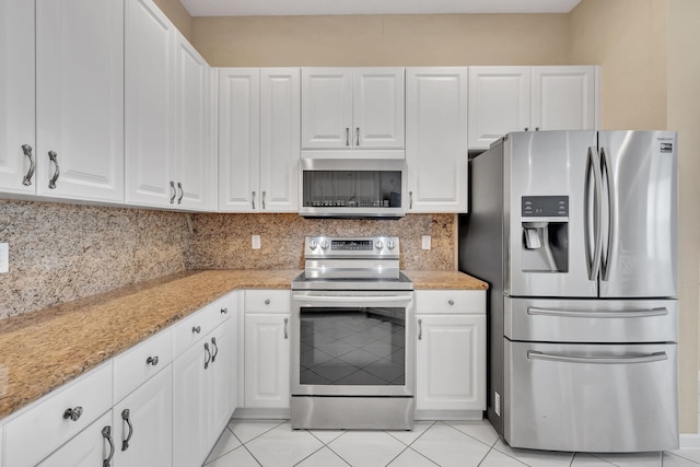 kitchen with white cabinets, decorative backsplash, stainless steel appliances, and light stone counters