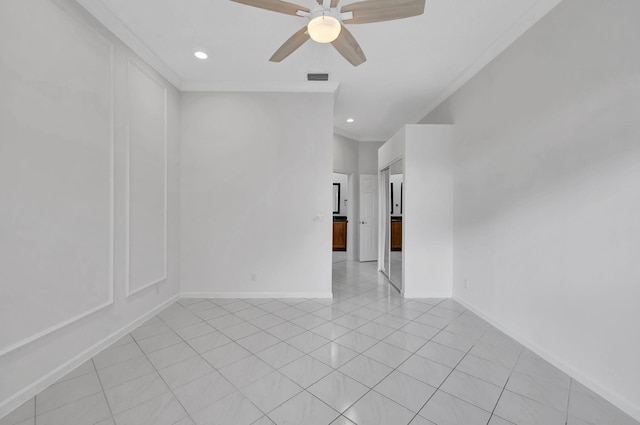 tiled spare room featuring ornamental molding and ceiling fan