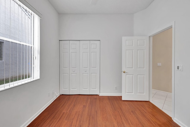 unfurnished bedroom featuring hardwood / wood-style floors and a closet