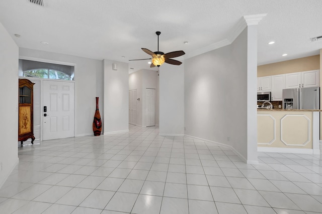 unfurnished living room featuring ceiling fan, a textured ceiling, light tile patterned floors, and ornamental molding