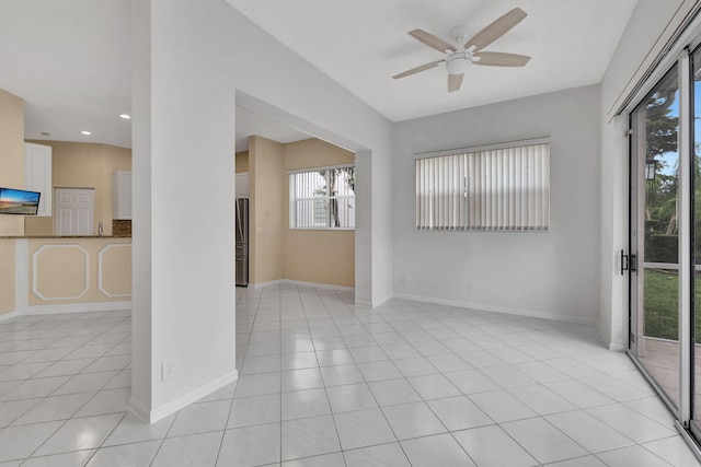 tiled spare room featuring ceiling fan and plenty of natural light