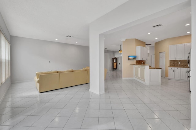 unfurnished living room featuring light tile patterned floors and ceiling fan